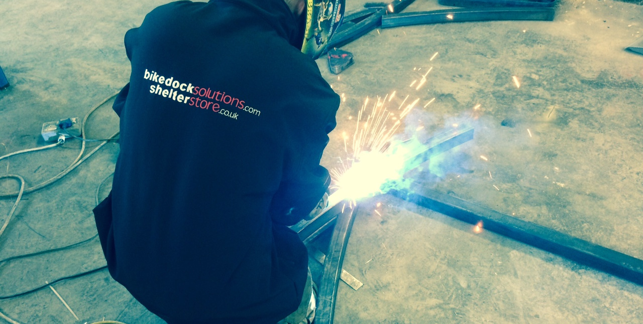 A Bike Dock Solutions and Shelter Store Staff Member welding an item